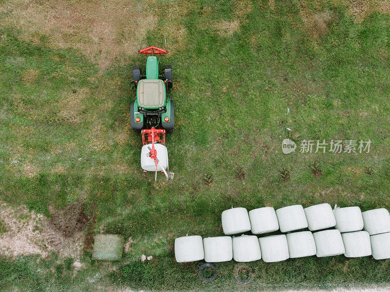 Tractor wrapping a hay bale